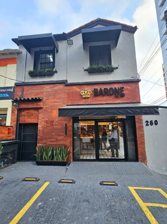 Fachada de loja com tijolinho aparente e letreiro da Sapataria Barone em São Paulo