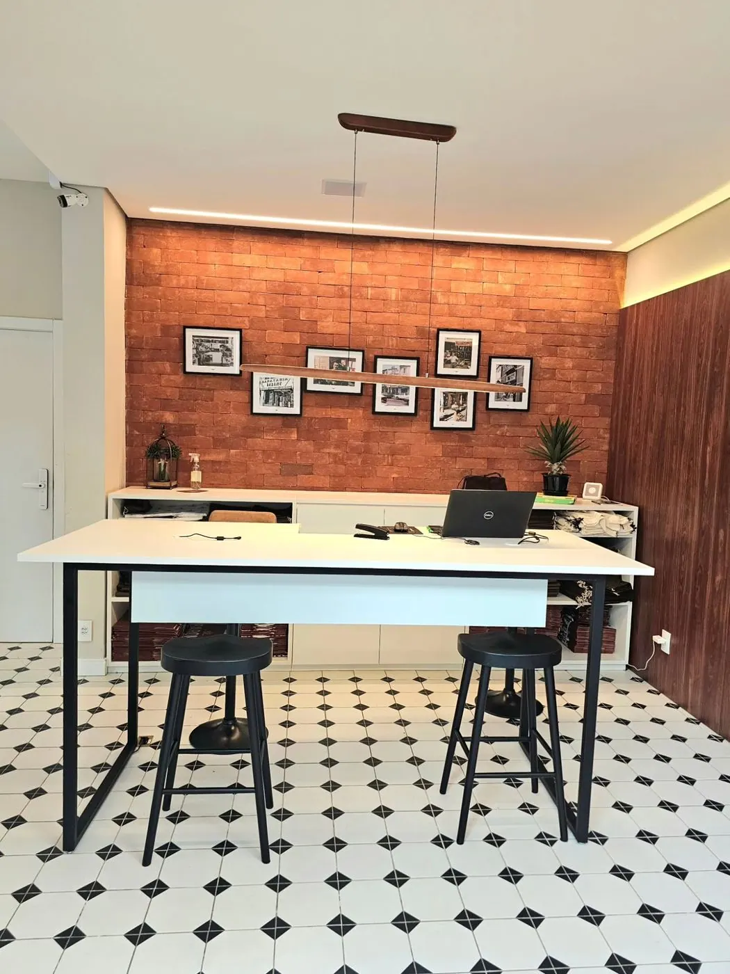 Ambiente de café com parede de tijolinho e fotos da família