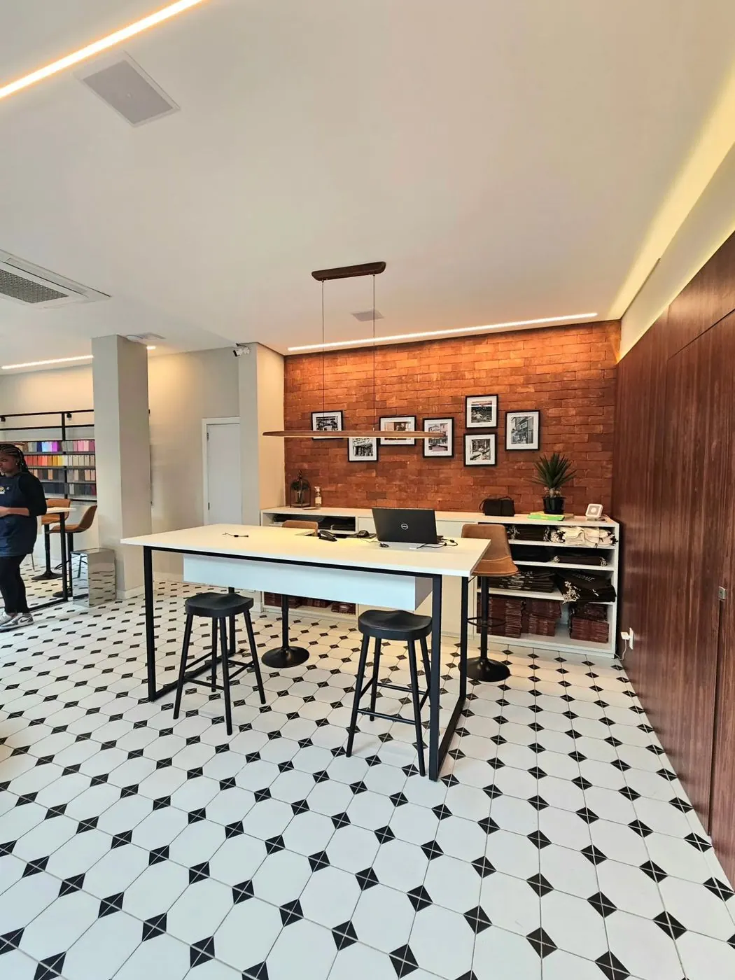 Mesa de atendimento com parede de tijolinho e piso hidráulico