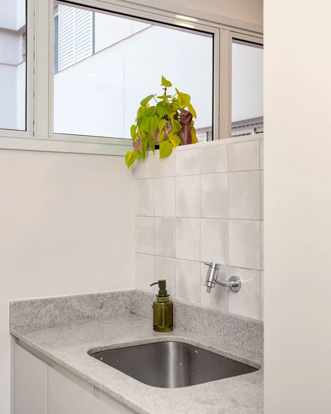 Detalhe da cuba de inox e bancada de granito na lavanderia