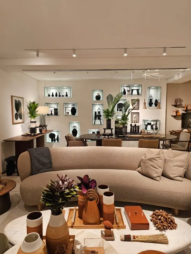 Sofá curvo em showroom com nichos iluminados ao fundo