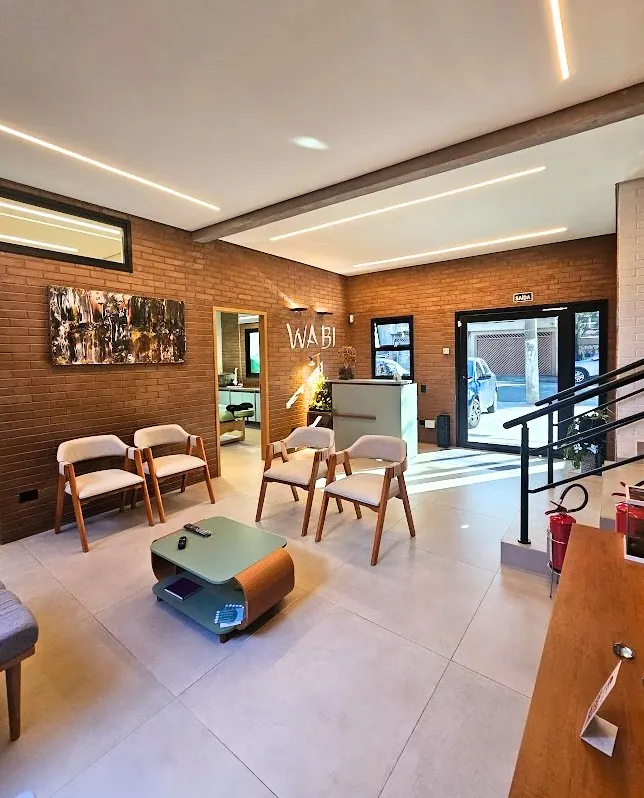 Estar da clínica com poltronas e mesa de centro orgânica